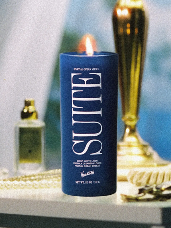 A scented candle from Vacation® featuring the fragrance of a relaxing ocean view suite, with a blend of fresh, coastal notes that evoke the feel of a serene beach getaway.