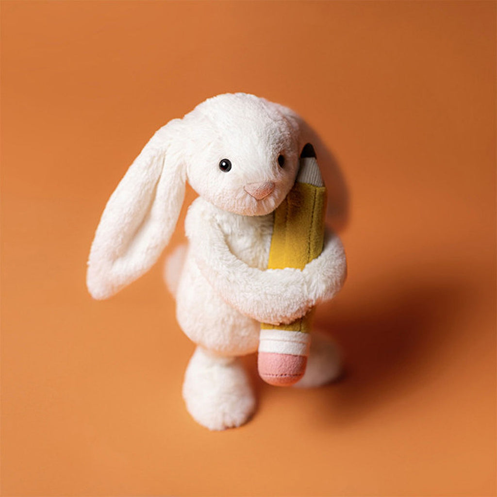 Jellycat Bashful Bunny with pencil, a soft, cuddly stuffed bunny holding a pencil, perfect for comforting and playful moments.