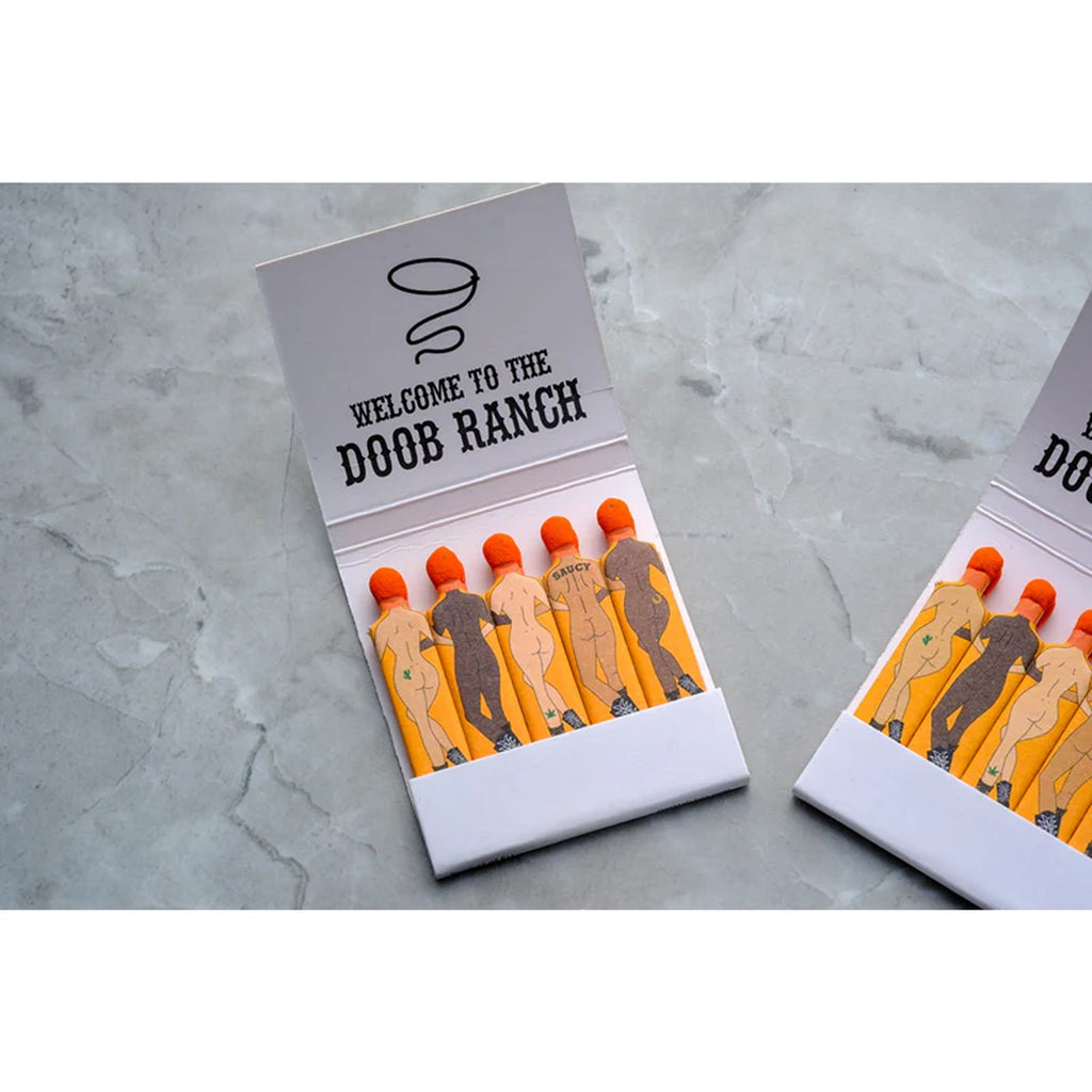 A matchbook from Doob Ranch, featuring a playful and rustic design on the cover. The matchbook contains several matchsticks and adds a touch of personality with its unique branding, perfect for lighting candles or creating a fun conversation piece.