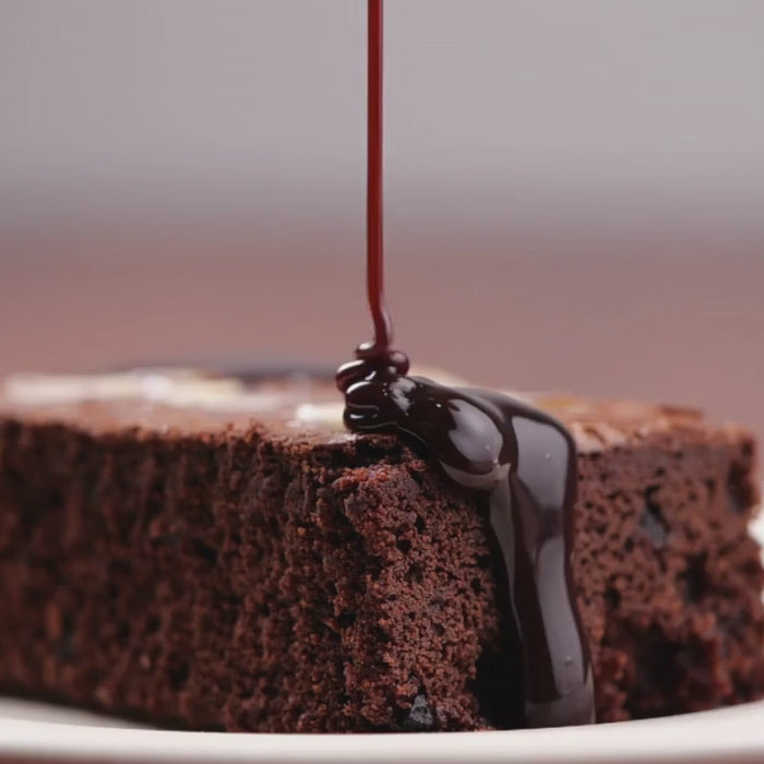 A small jar of rich, creamy vegan hot fudge, made without dairy, perfect for drizzling over desserts or enjoying as a sweet treat.